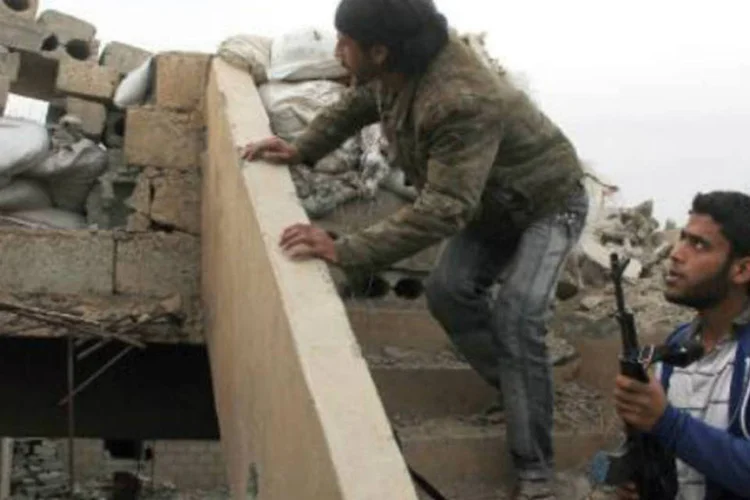
	Rebeldes em barricada constru&iacute;da no telhado de um pr&eacute;dio na cidade s&iacute;ria de Deir Ezzor
 (Ahmad Aboud/AFP)