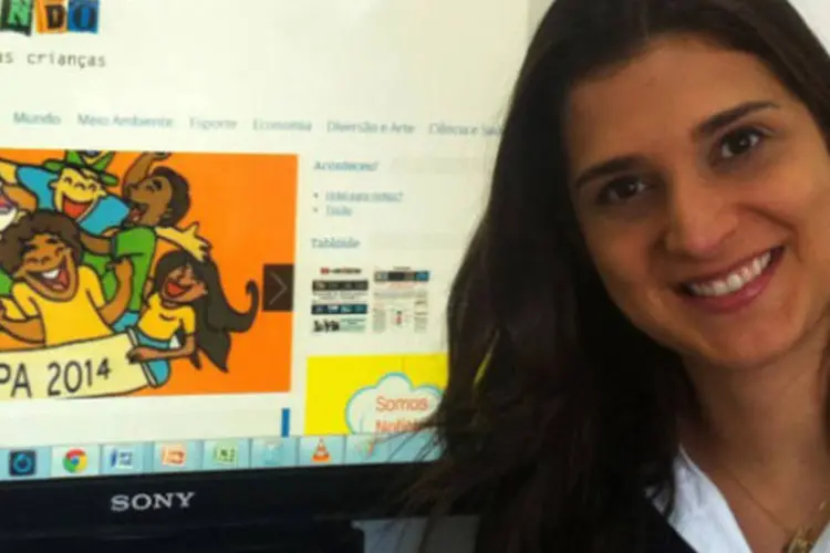 Jornalista Simone Ronzani com a página do site Recontando, que reconta notícias do mundo para crianças (Cássia Maria/Divulgação)