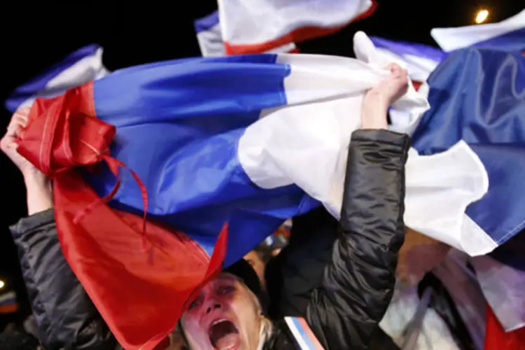 
	Mulher celebra resultados preliminares de referendo sobre uni&atilde;o da Crimeia &agrave; R&uacute;ssia, na Lenin Square, na capital da Crimeia, Simferpol, no dia 16 de mar&ccedil;o de 2014
 (REUTERS/David Mdzinarishvili)
