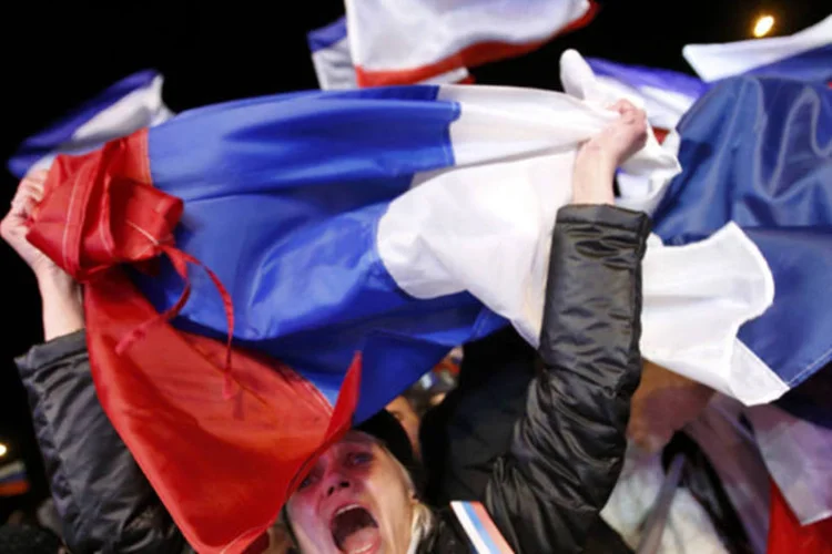 
	Mulher celebra resultados preliminares de referendo sobre uni&atilde;o da Crimeia &agrave; R&uacute;ssia: &eacute; prov&aacute;vel que a UE passe &agrave; pr&oacute;xima fase de san&ccedil;&otilde;es, logo que l&iacute;deres se reunirem na quinta-feira, com a expans&atilde;o da lista de nomes
 (REUTERS/David Mdzinarishvili)