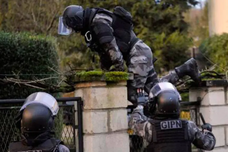 Agente do corpo de elite da polícia salta muro em 8 de janeiro em Corcy, no norte da França
 (Francçois Lo Presti/AFP)