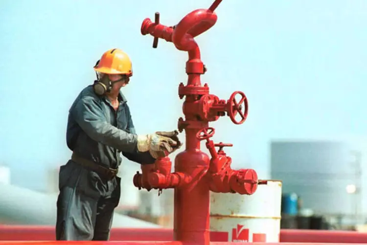 
	Trabalhador em uma refinaria da Petroleos: h&aacute; previs&atilde;o de investir 15 bilh&otilde;es de d&oacute;lares em 2015
 (Diego Giudice/Bloomberg News)