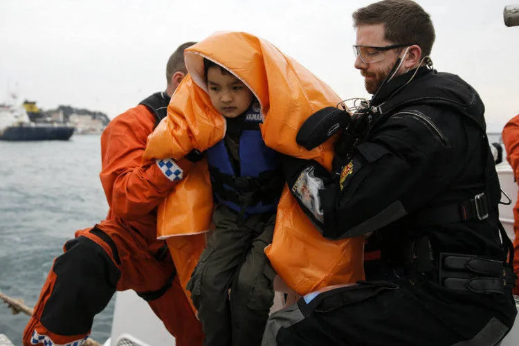 
	Menino refugiado &eacute; resgatado e auxiliado por volunt&aacute;rio a desembarcar na ilha Lesbos, na Gr&eacute;cia: &eacute; incerto se a queda no n&uacute;mero possui rela&ccedil;&atilde;o direta com o acordo
 (Alkis Konstantinidis/Reuters)