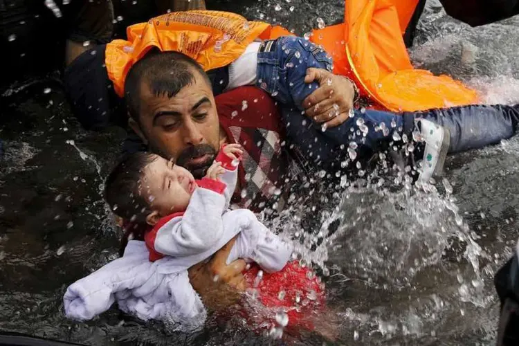 
	Refugiado segura crian&ccedil;a em chegada &agrave; Gr&eacute;cia: o acidente de hoje aconteceu um dia depois que tr&ecirc;s pessoas morreram em um naufr&aacute;gio de uma embarca&ccedil;&atilde;o com 21 refugiados a bordo
 (REUTERS/Yannis Behrakis)