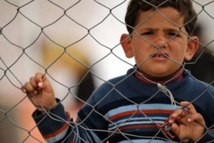 Um menino sírio refugiado observa a movimentação no campo de Reyhanli: mais de 30.000 refugiados foram registrados pelo Acnur (Bulent Kilic/AFP)