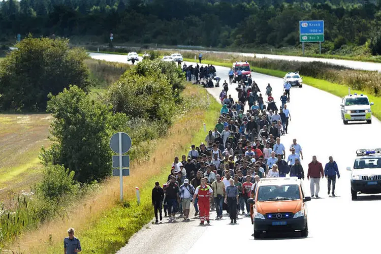 
	Refugiados caminhando em estrada da Dinamarca para chegar na Su&eacute;cia: a posi&ccedil;&atilde;o contr&aacute;ria &eacute; apresentada pela Alemanha, pa&iacute;s l&iacute;der de uma pol&iacute;tica de portas abertas que anunciou nesta quinta-feira que 450.000 refugiados foram registrados no pa&iacute;s durante o ano
 (Reuters / Claus Fisker)
