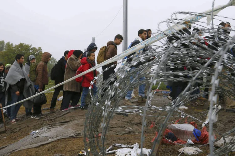 
	Refugiados cruzam a fronteira da Cro&aacute;cia com a Hungria: neste ano, mais de 370.000 refugiados entraram na Hungria, provenientes de pa&iacute;ses em conflito do Oriente M&eacute;dio
 (Reuters / Laszlo Balogh)