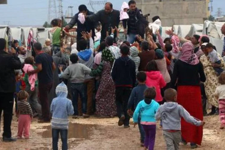 Refugiados curdos de Kobane recebem toalhas, em um campo improvisado na cidade turca de Suruc (Zein Al-Rifai/AFP)