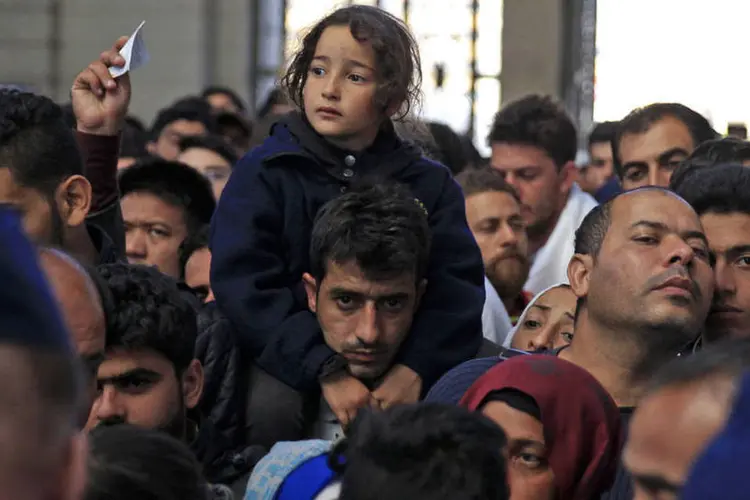 
	Refugiados esperam para embarcar em trem na Europa
 (Reuters / Bernadett Szabo)