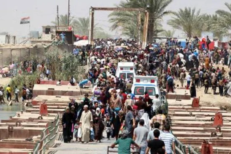 Moradores que fugiram de Ramadi cruzam uma ponte na divisa com Bagdá (Sabah Arar/AFP)