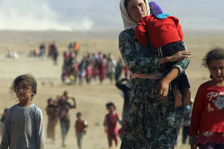 
	Membros da minoria yazidi fugindo da viol&ecirc;ncia das for&ccedil;as leais ao Estado Isl&acirc;mico
 (Rodi Said/Reuters)