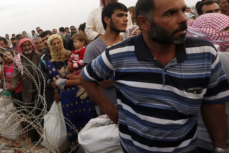 Refugiados querendo cruzar fronteira: pelo menos 412 morreram em combates, diz ONG (Murad Sezer/Reuters)