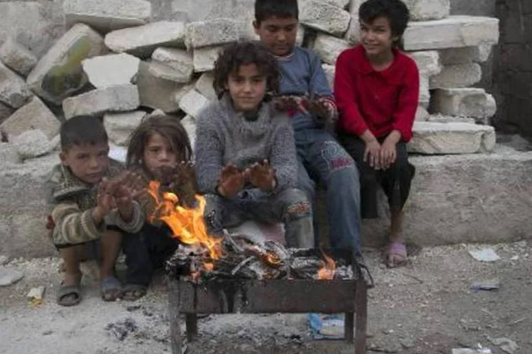 Crianças se protegem do frio, na cidade síria de Aleppo: campanha para reunir fundos através das redes sociais continua, com o tema "Um dólar, uma vida" (Baraa al-Halabi/AFP)