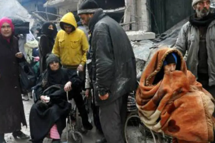 Moradores do campo de refugiados de Yarmuk, Síria, aguardam para receber comida doada pela ONU: quase 200 pessoas morreram no local devido às privações (AFP)