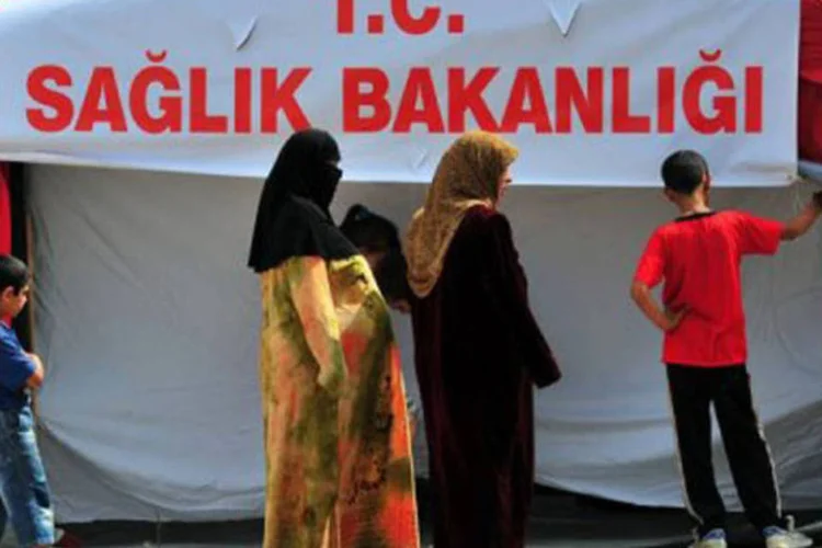 Refugiados sírios aguardam atendimento médico da Cruz Vermelha em Boynuyogun, Turquia (Mustafa Ozer/AFP)