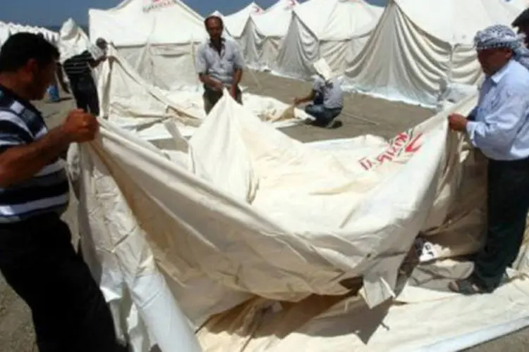 Funcionários do Crescente Vermelho turco montam barracas em acampamento de refugiados na cidade de Apaydin: general desertor sírio defende um governo interino de coalizão (Adem Altan/AFP)