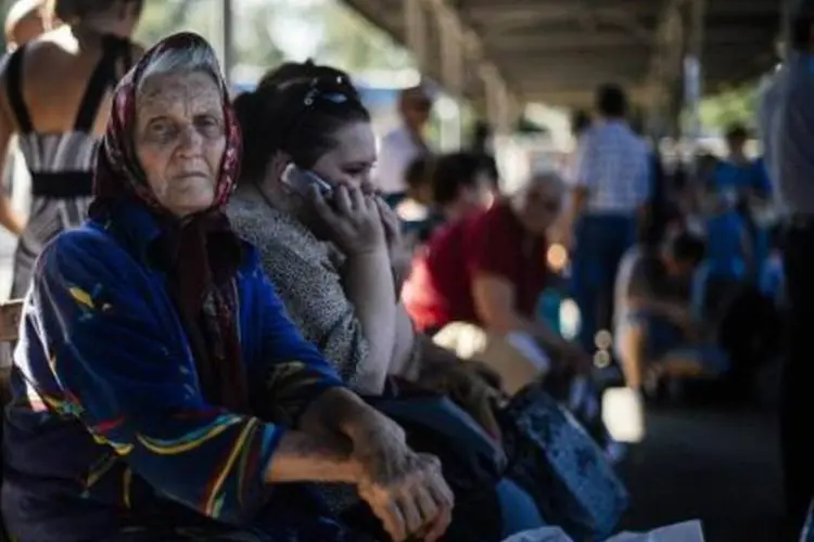 Ucranianos aguardam um ônibus que os levará embora de Donetsk, cidade controlada pelos rebeldes (Dimitar Dilkoff/AFP)