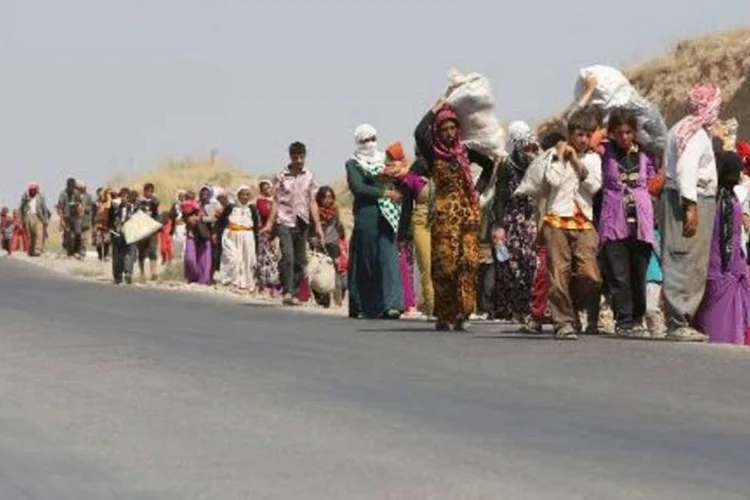 Famílias iraquianas da comunidade yazidi se aproximam da fronteira com a Síria (Ahmad al-Rubaye/AFP)