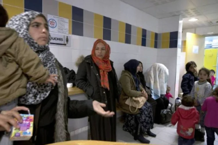 
	Fam&iacute;lias de refugiados em Paris: os 31 refugiados, entre eles um menino de tr&ecirc;s anos, est&atilde;o s&atilde;os e salvos
 (AFP / Joel Saget)