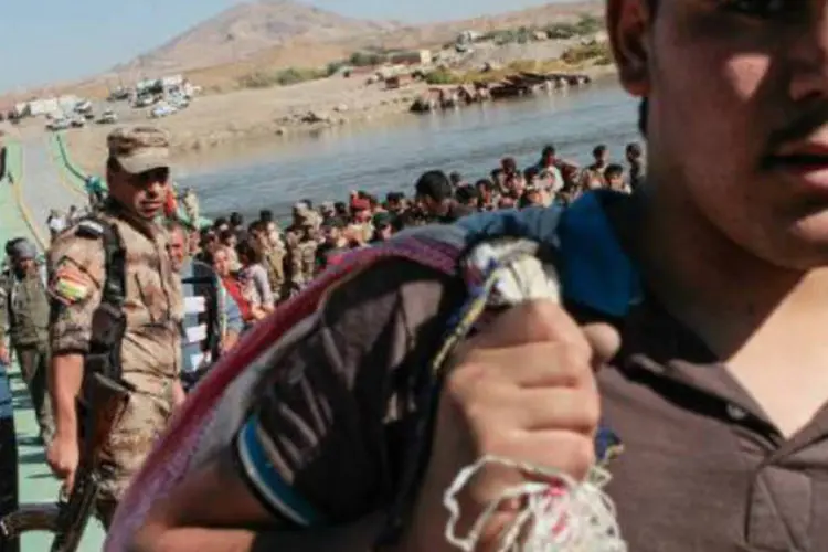 Refugiados sírios retornam ao país após serem barrados na fronteira com o Iraque em 23 de outubro de 2013 (AFP)
