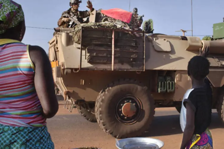 Moradores de vilarejo acenam para soldados franceses de passagem pela cidade de Konobougou, no Mali (Joe Penney/Reuters)
