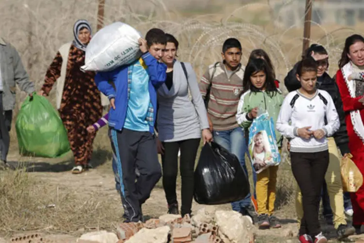 Sírios do norte da cidade de Ras al-Ain andam na fronteira turco-síria para voltar para suas casas, em Ceylanpinar, na província de Sanliurfa (REUTERS/Murad Sezer)