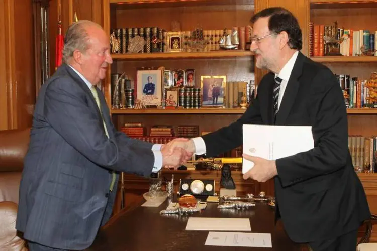 
	Juan Carlos cumprimenta o primeiro-ministro Mariano Rajoy ap&oacute;s abdicar ao trono espanhol
 (Casa Real Espanhola/Divulgação via Reuters)