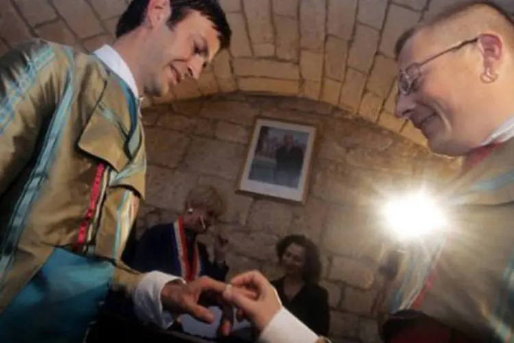 Homens trocam votos em Montpellier, França: o direito ao casamento e à adoção para casais homossexuais são compromissos de campanha do presidente François Hollande (©AFP/File / Dominique Faget)