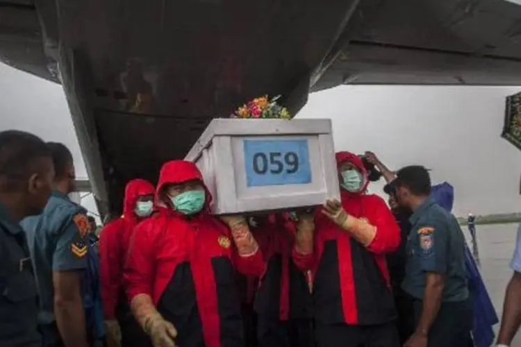 Equipe de salvamento da Indonésia carrega caixão de corpo encontrado no mar de vítima do acidente do voo QZ8501 da companhia AirAsia (Juni Kriswanto/AFP)