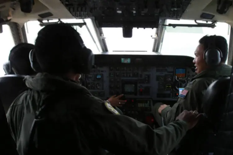 
	Pilotos da For&ccedil;a A&eacute;rea Real da Mal&aacute;sia trabalham na cabine de um CN235 da aeron&aacute;utica malaia durante uma miss&atilde;o de busca e resgate pelo voo MH370
 (Samsul Said/Reuters)