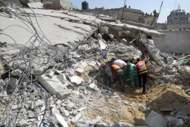Equipes de resgate em meio a ruínas em Gaza, em 21 de julho de 2014: mais de 570 palestinos foram mortos em 14 dias de ofensivas (Mahmud Hams/AFP)