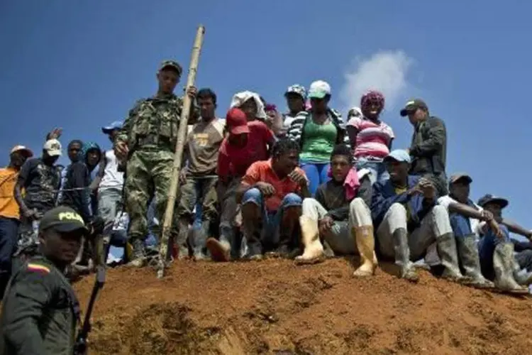 Pessoas e policiais tentam resgatar mineiros após desabamento de mina: desabamento deixou até o momento três mortos (Luis Robayo/AFP)