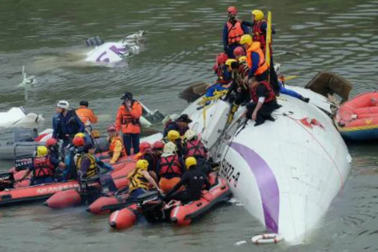 Equipes de resgate tentam retirar passageiros do avião ATR 72-600 da TransAsia Airways de rio em Taiwan (Sam Yeh/AFP)