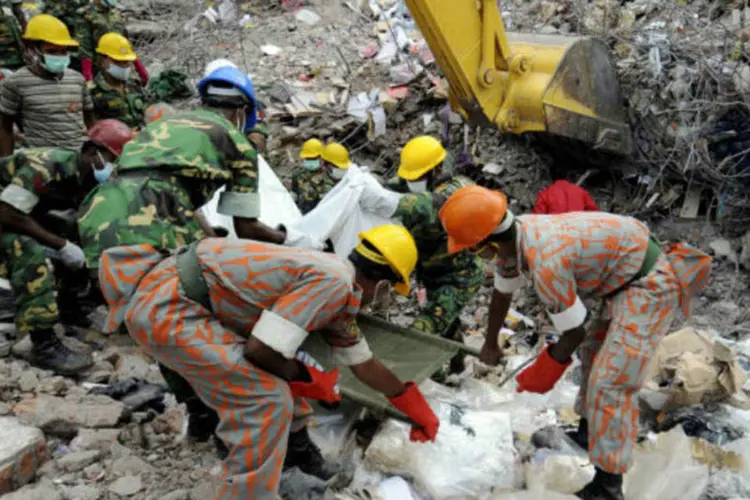 Equipes de resgate carregam corpo de vítima do desabamento de edifício em Bangladesh (REUTERS/Stringer)