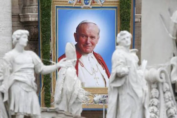 
	Tape&ccedil;aria com retrato de Jo&atilde;o Paulo II na bas&iacute;lica de S&atilde;o Pedro, no dia de sua canoniza&ccedil;&atilde;o
 (REUTERS/Stefano Rellandini)