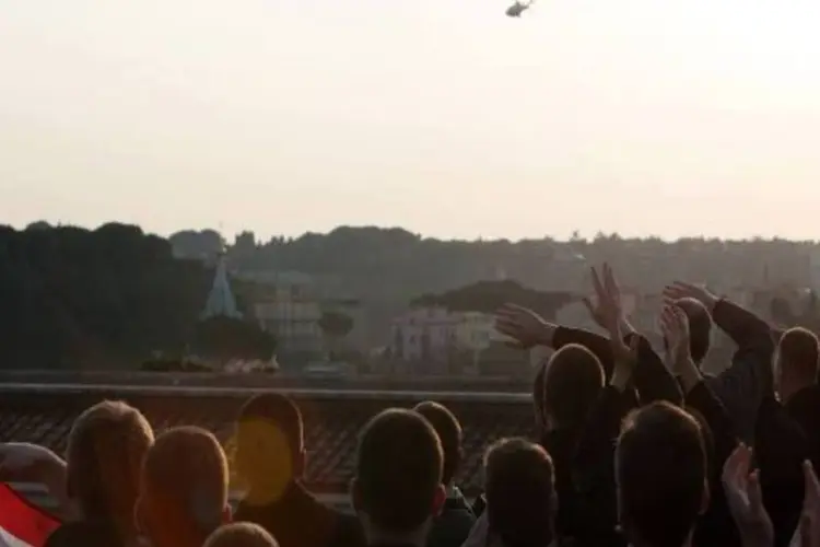 Fiéis observam helicóptero que transporta Bento XVI (Reuters)