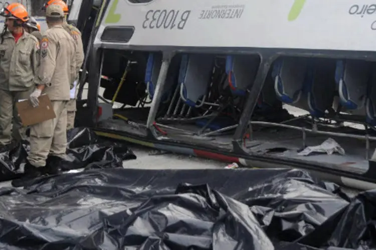 Corpos das sete vítimas de acidente, cobertos por lona, são vistos próximos aos destroços do ônibus que despencou de viaduto na zona norte do Rio de Janeiro (REUTERS/Fabio Teixeira)