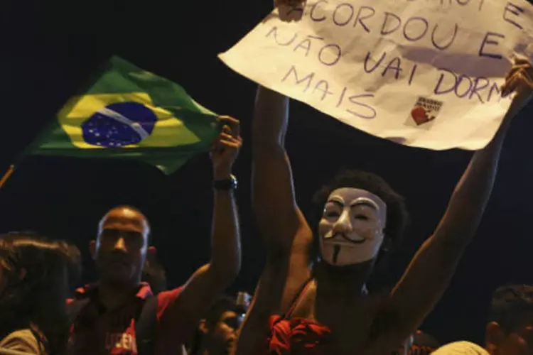
	Manifestante com m&aacute;scara do Guy Fawkes segura cartaz: para o PSB, a reforma urbana foi a mensagem mais importante das recentes manifesta&ccedil;&otilde;es populares.
 (REUTERS/Pilar Olivares)