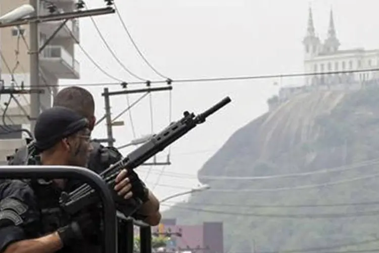 Policiais patrulham a rua durante operação na favela Vila Cruzeiro, no Rio de Janeir (REUTERS)