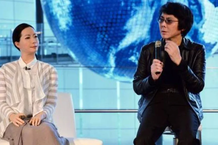 O cientista japonês Hiroshi Ishiguro (d) e uma de sua invenções, Otonaroid, em Tóquio (Yoshikazu Tsuno/AFP)