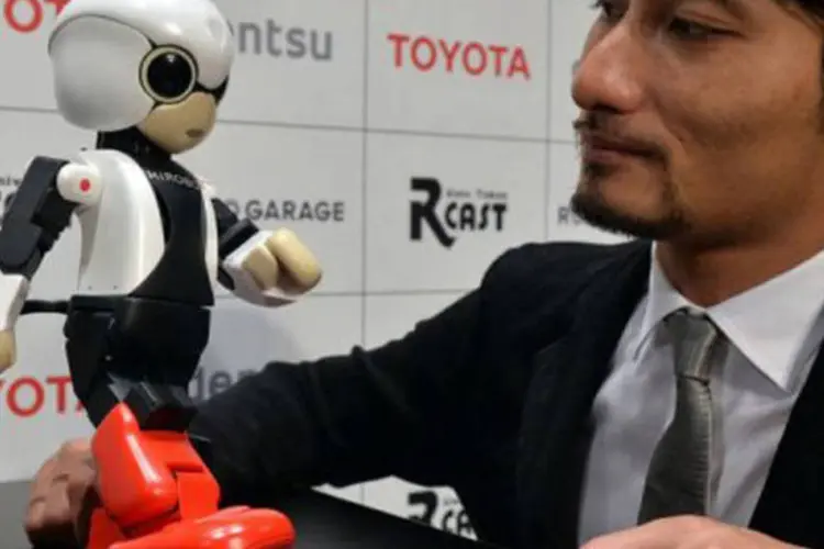 Takahashi faz uma demonstração com o robô: o objetivo do projeto é estudar em que medida um robô de companhia pode dar apoio moral a pessoas isoladas durante um longo período de tempo. (AFP / Yoshikazu Tsuno)