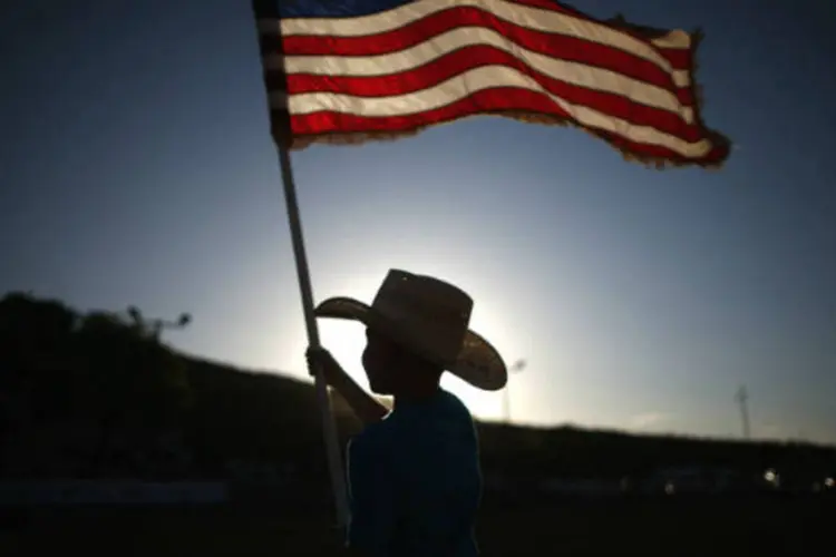 
	Menino segura bandeira dos Estados Unidos durante rodeio no Novo M&eacute;xico
 (REUTERS/Lucy Nicholson)
