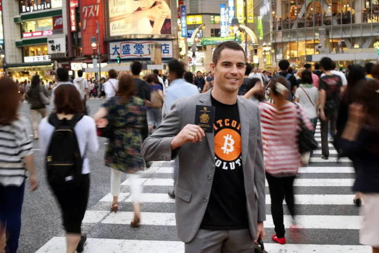 Roger Ver, fundador do Passports for Bitcoin.com, mostra o seu passaporte em Shibuya (Tomohiro Ohsumi/Bloomberg)