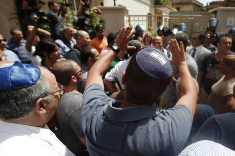 Pessoas discutem com policial durante protesto: houve breve confusão quanto um homem identificado como neto de Priebke chegou com champanhe e manifestantes o empurraram (Yara Nardi/Reuters)