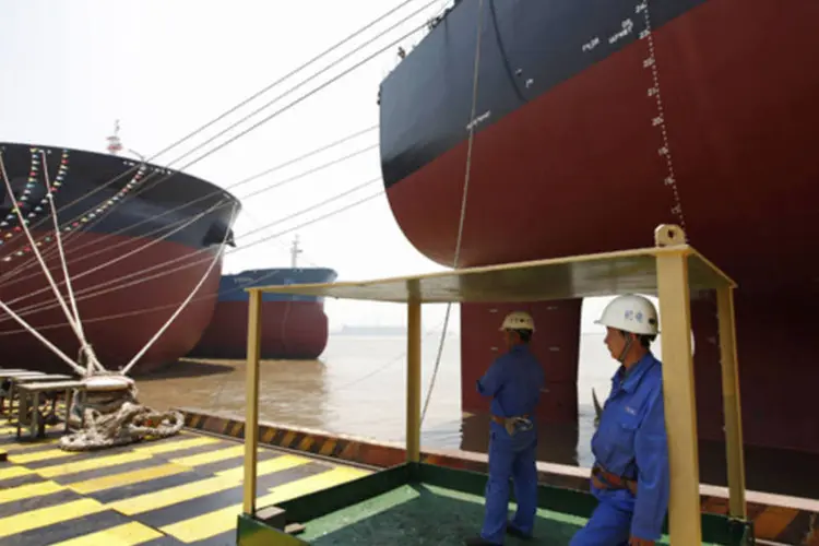 
	Trabalhadores em frente a dois navios Valemax: uma decis&atilde;o da China de relaxar as restri&ccedil;&otilde;es de transporte neste tipo de navio ser&aacute; um est&iacute;mulo estrat&eacute;gico para &nbsp;a Vale
 (Aly Song/Arquivo/Reuters)