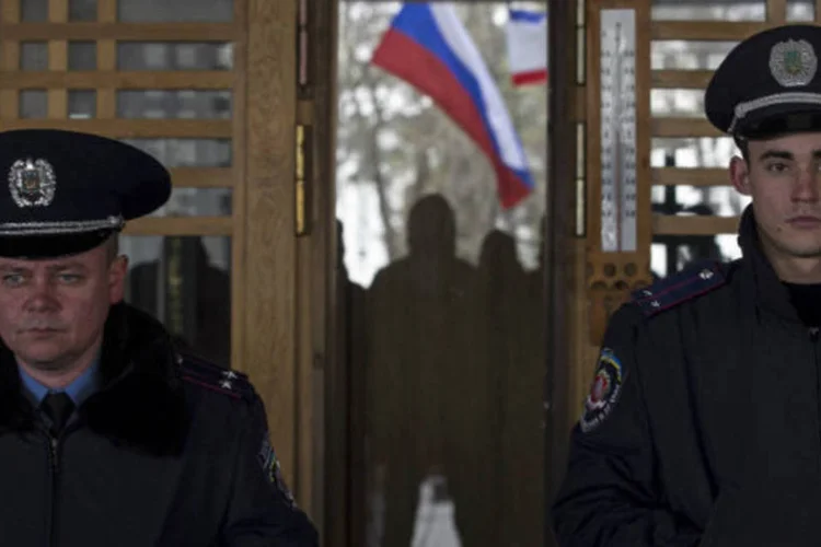 Bandeira da Rússia atrás de policiais que fazem guarda durante protesto na Ucrânia: foram registrados pequenos distúrbios (Baz Ratner/Reuters)