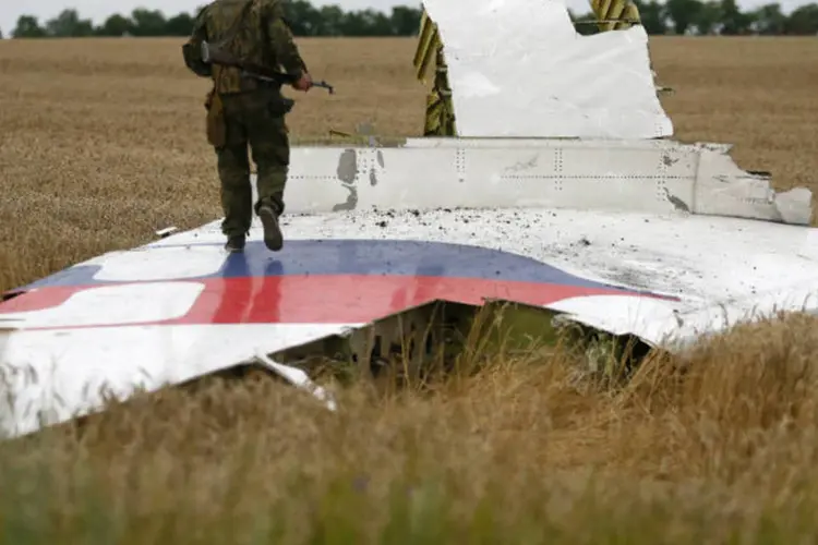 Militante pró-Rússia caminha sobre destroços de avião da Malásia que caiu na Ucrânia (Maxim Zmeyev/Reuters)