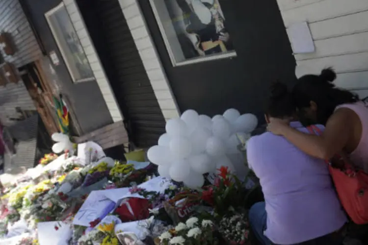 Mulheres deixam flores na porta da boate Kiss, na cidade de Santa Maria, onde um incêndio matou 231 pessoas ( REUTERS/ Ricardo Moraes)