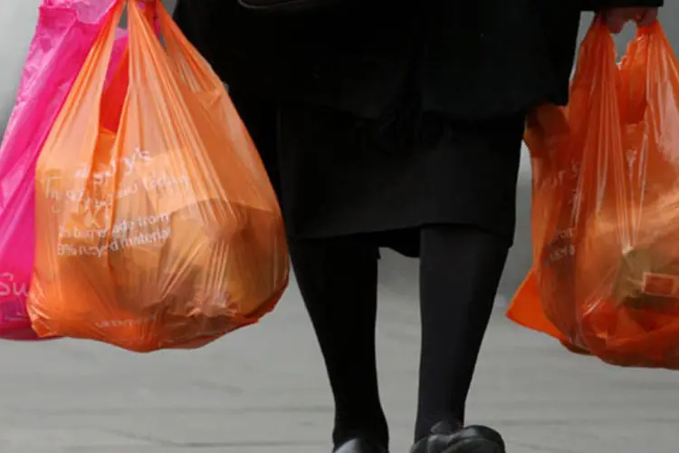 Mulher carrega sacolas plásticas: o setor tem recorrido à Justiça para tentar banir a distribuição gratuita das sacolas
