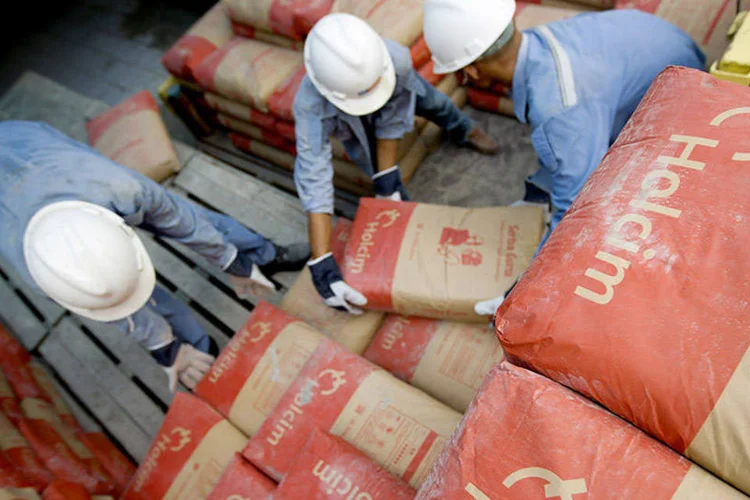 
	Trabalhadores em distribuidora da Holcim: anunciado em abril de 2014, o acordo previa combinar as empresas em condi&ccedil;&otilde;es de igualdade
 (Kemal Jufri/Bloomberg News)